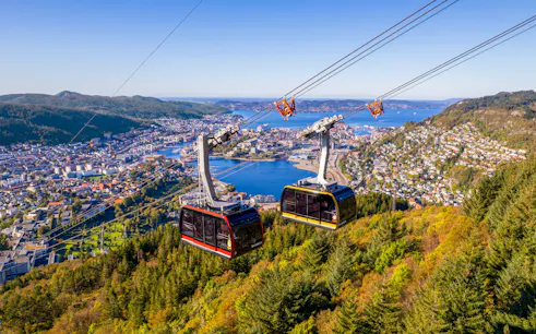 Ulriken cable cars ascending over Bergen, Norway with city and fjord views.