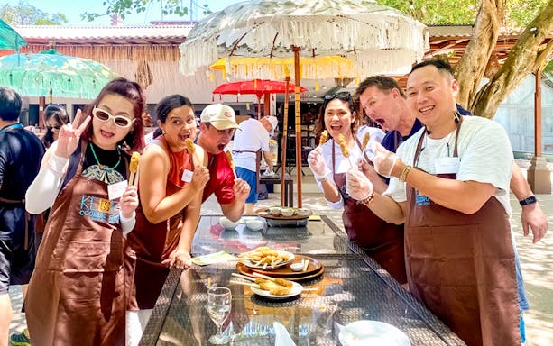 Participants enjoying satay skewers at Kekeb Balinese Cooking Class in Nusa Dua.