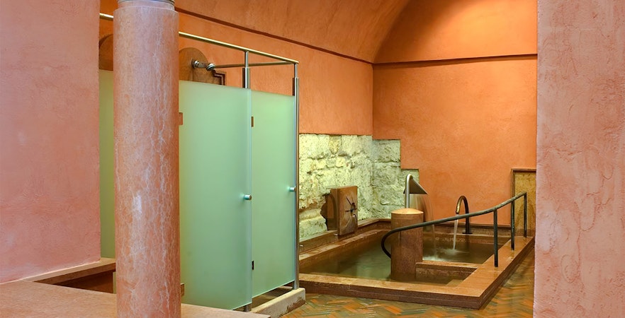 Rudas Thermal Spa interior with stone walls and a thermal pool.