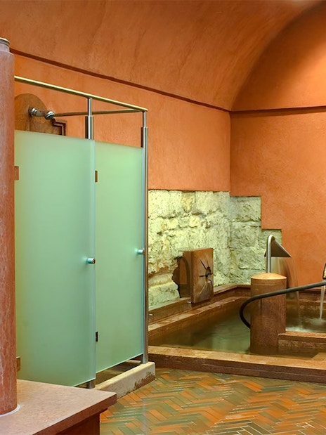 Rudas Thermal Spa interior with stone walls and a thermal pool.