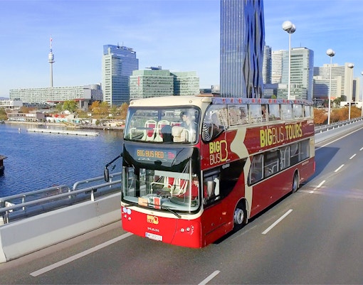 Tourists on Vienna Hop-On Hop-Off Bus Tour with Ferris Wheel and Danube River Cruise in view