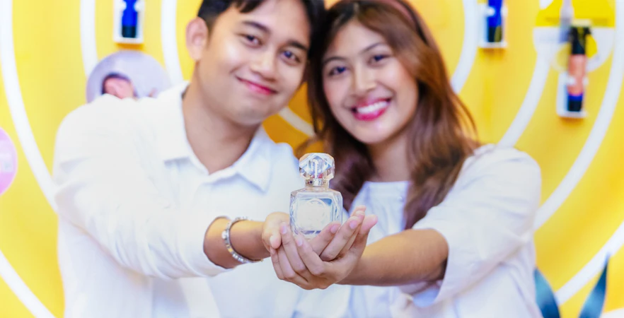 Couple holding perfume bottle at Scentopia Sentosa Singapore.