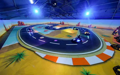 Kart racing on a digital track at Chaos Karts Dubai, featuring immersive projections.