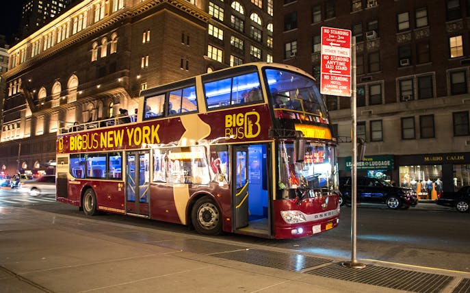 Double-decker bus on New York Holiday Lights Tour at night.