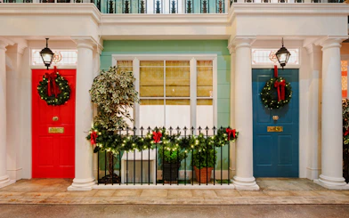 Festive wreaths on red and blue doors in Paddington, London, during Christmas.