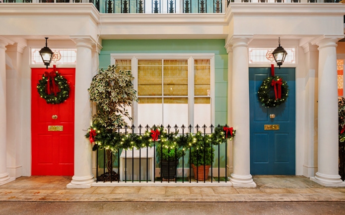 Festive wreaths on red and blue doors in Paddington, London, during Christmas.
