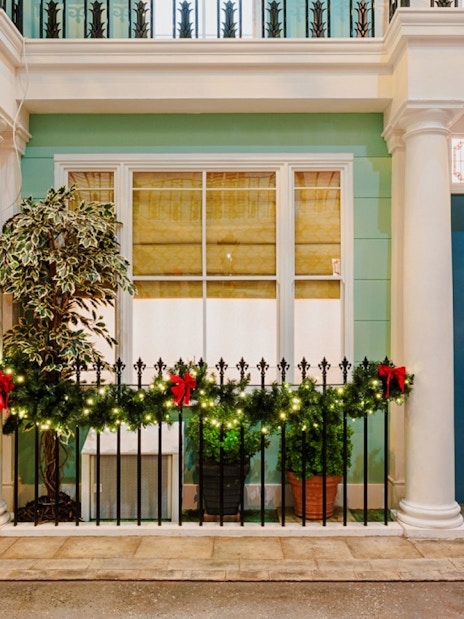 Festive wreaths on red and blue doors in Paddington, London, during Christmas.