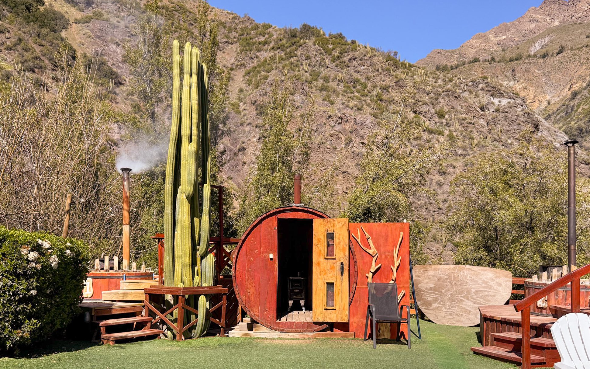 Glamping cabin with cactus and mountain backdrop in Cajón del Maipo, Chile.