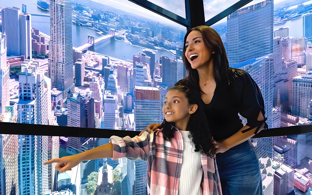 Visitors enjoying digital skyline display in One World Observatory elevator, New York City.