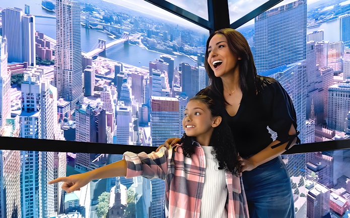 Visitors enjoying digital skyline display in One World Observatory elevator, New York City.