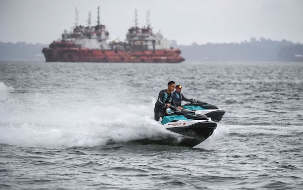 Jet skis on a Seadoo Safari in Johor Bahru with ships in the background.