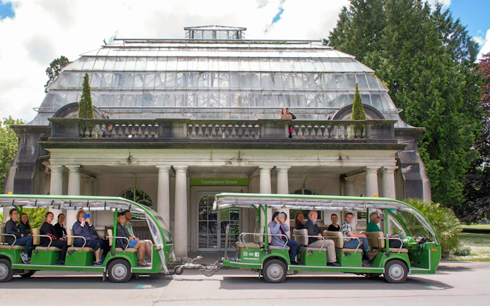 Tour group in green tram at Cunningham House, Botanic Gardens, Christchurch.