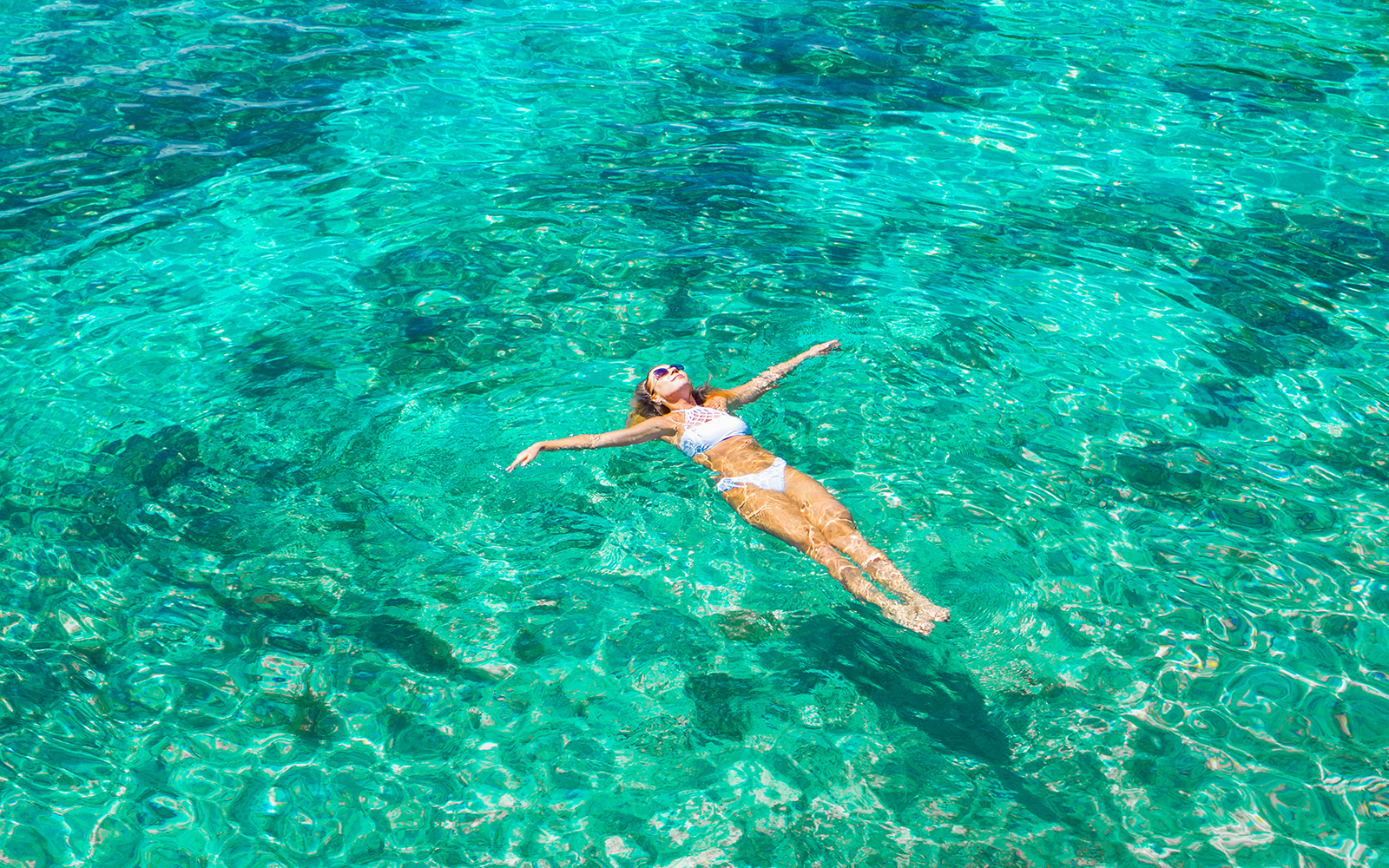 Woman swimming in clear ocean water.