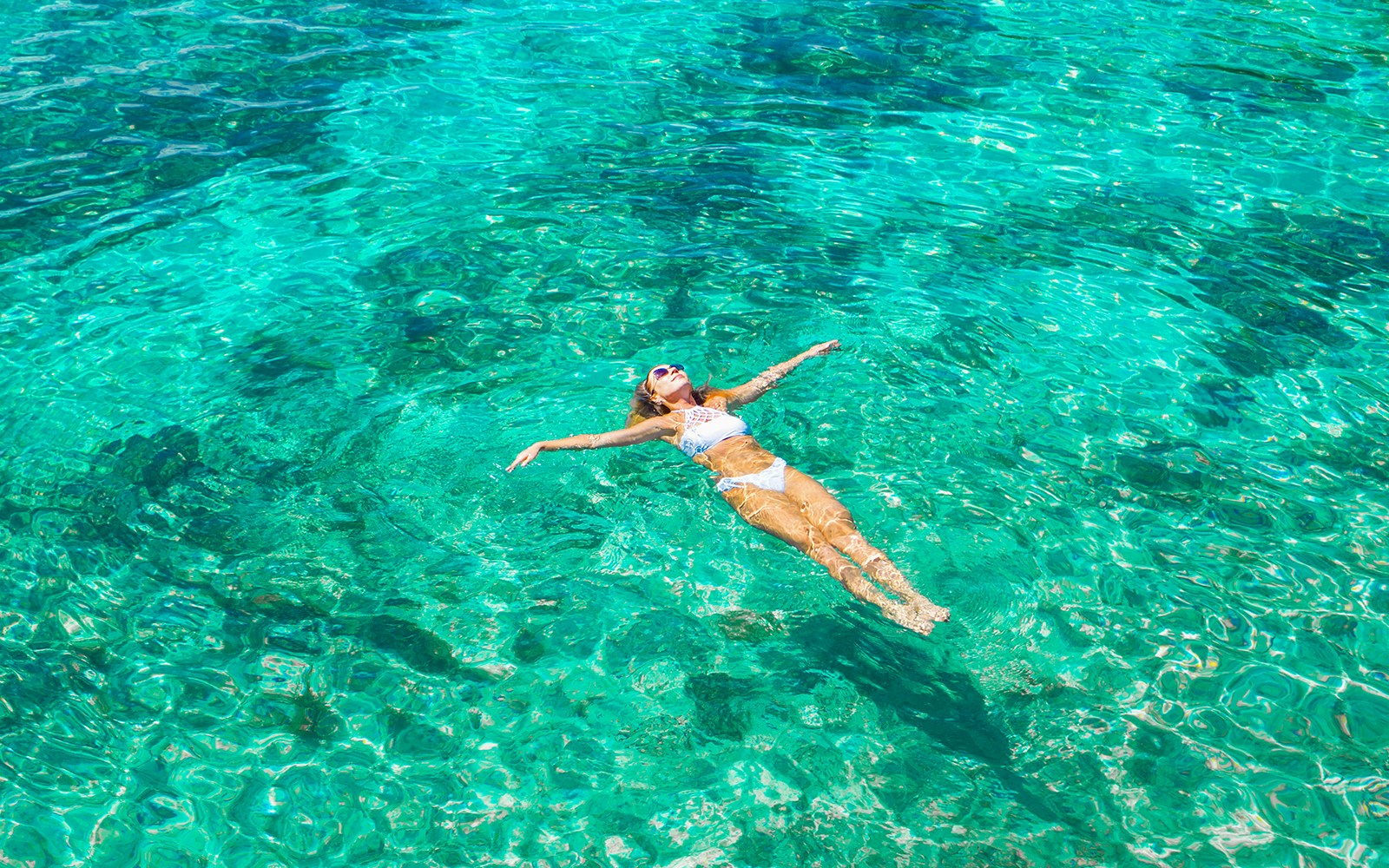 Woman swimming in clear ocean water.
