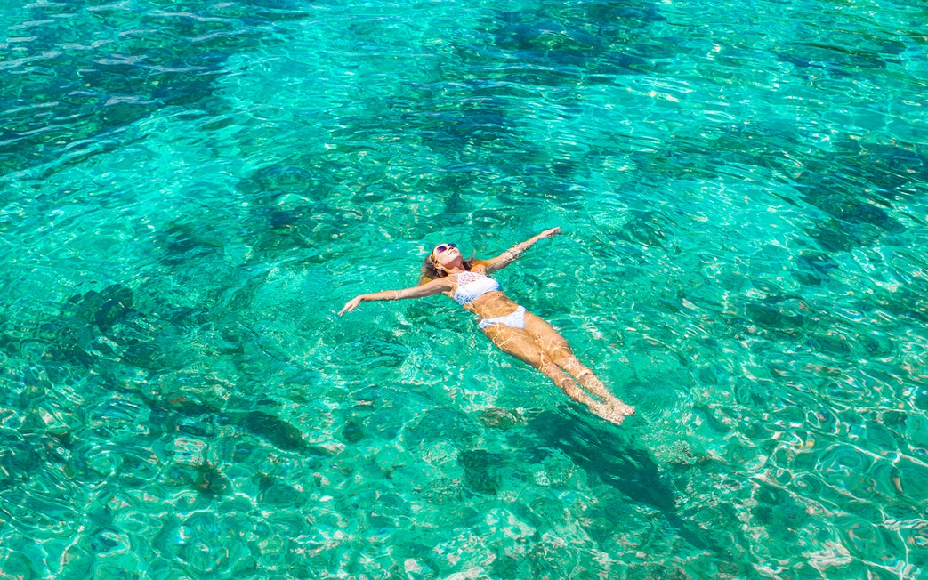 Woman swimming in clear ocean water.