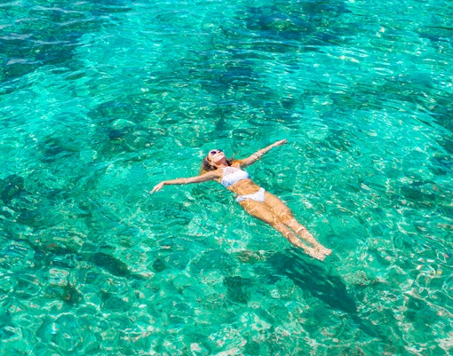 Woman swimming in clear ocean water.