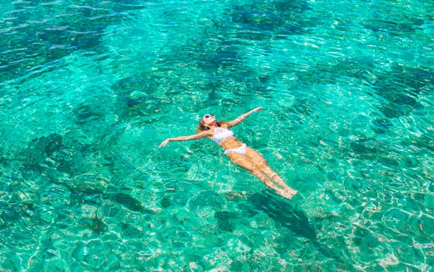 Woman swimming in clear ocean water.