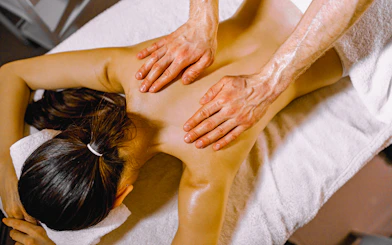 Person receiving an oil massage on a spa table.