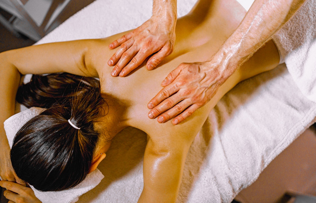 Relaxing oil massage session with a therapist applying oil on a client's back at a spa.