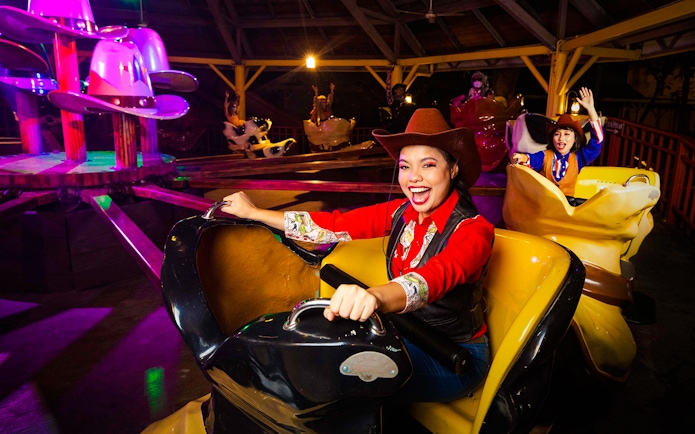 Visitors enjoying a cowboy-themed ride at Sunway Lagoon night park.