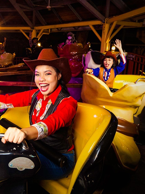 Visitors enjoying a cowboy-themed ride at Sunway Lagoon night park.
