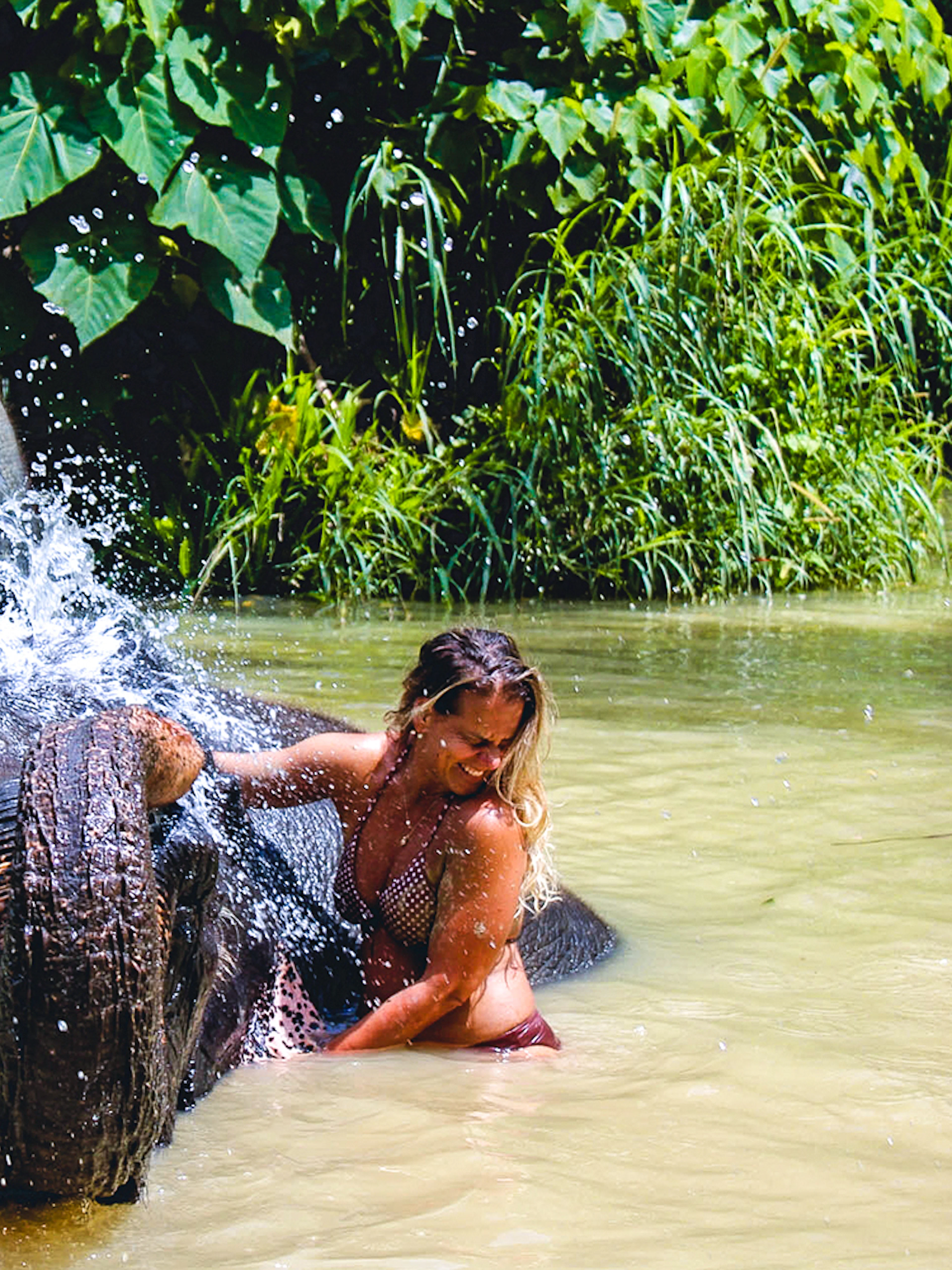 Elephant bathing with visitor at Ao Nang Elephant Sanctuary, Thailand.