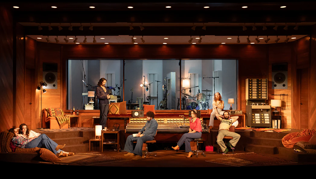 Recording studio scene with people interacting around a mixing console, Stereophonic theme.