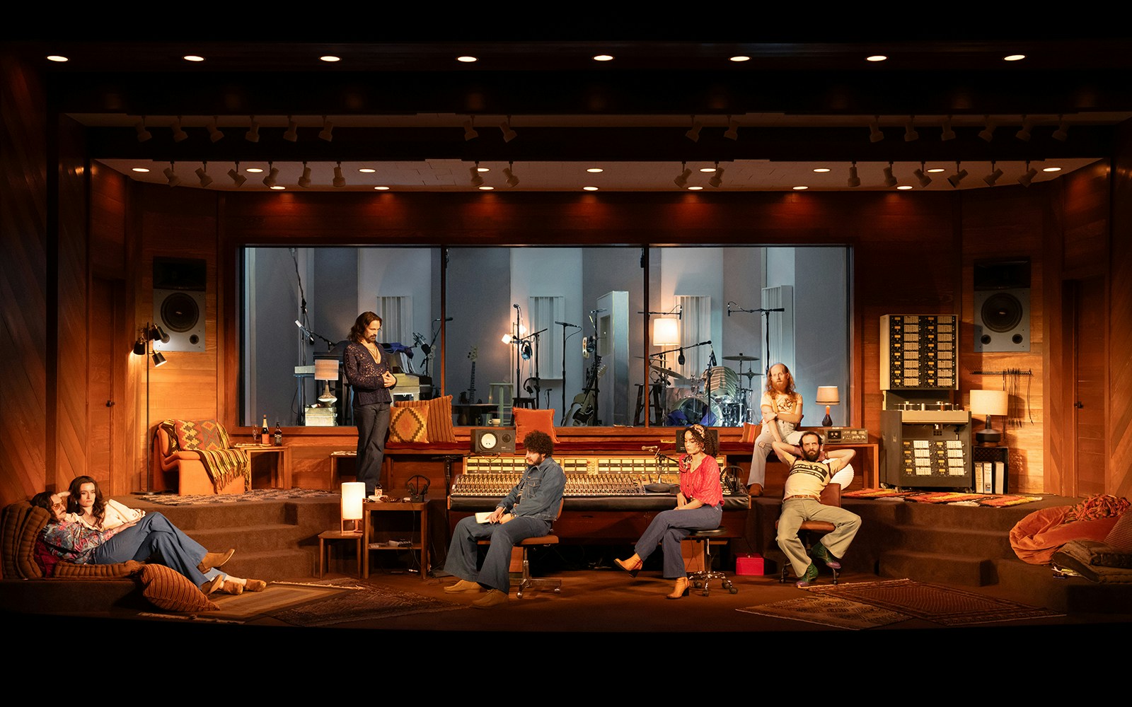 Recording studio scene with people interacting around a mixing console, Stereophonic theme.