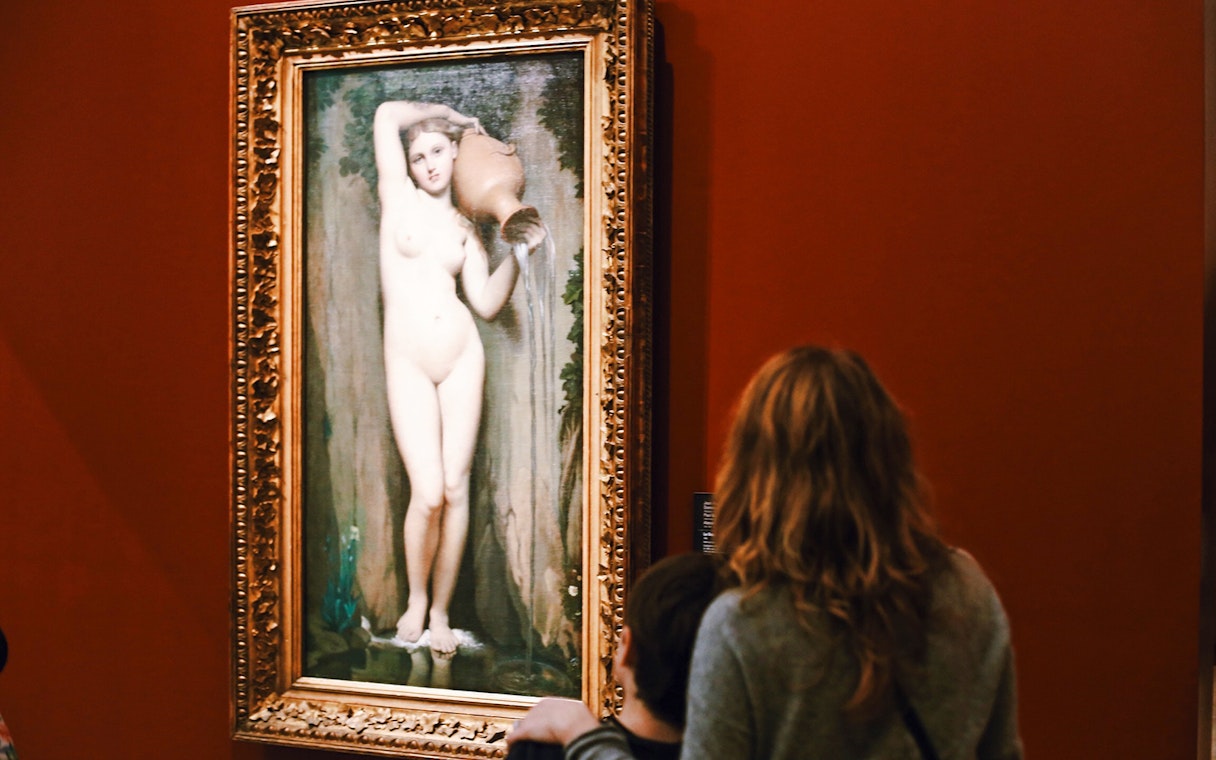 Visitors viewing a painting at Orsay Museum, Paris, France.