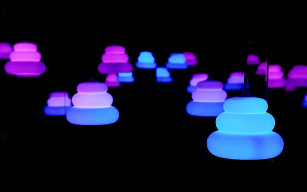 Colorful poop-shaped lanterns in blue and purple glow at Unko Museum, Japan.