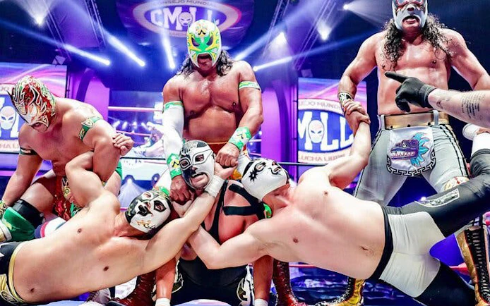 Lucha Libre wrestlers in colorful masks performing in a vibrant arena in Mexico City.