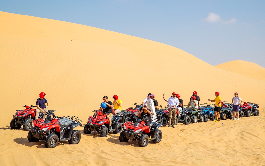 Group on quad bikes in Abu Dhabi desert tour.