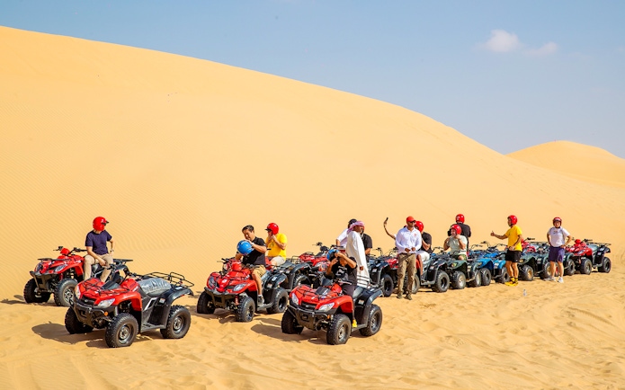 Group on quad bikes in Abu Dhabi desert tour.