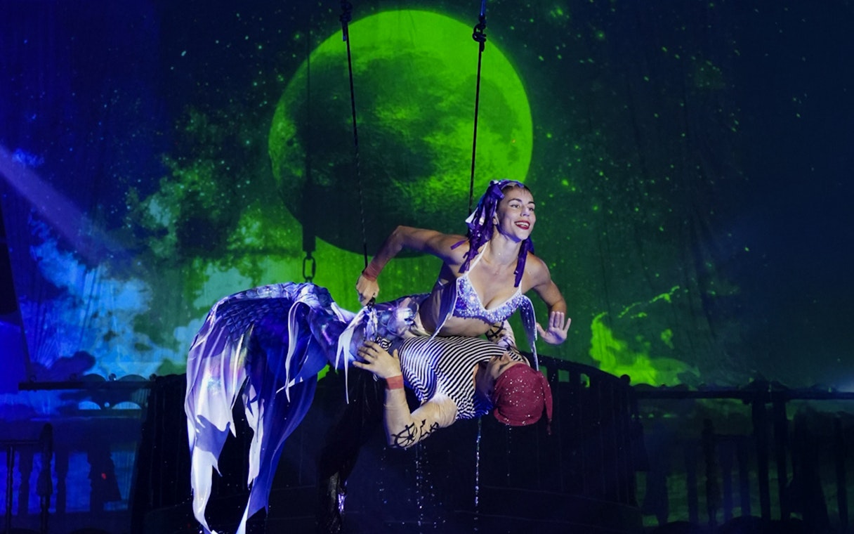 Aerial performer at Aqua Circus Phuket with a moonlit backdrop.