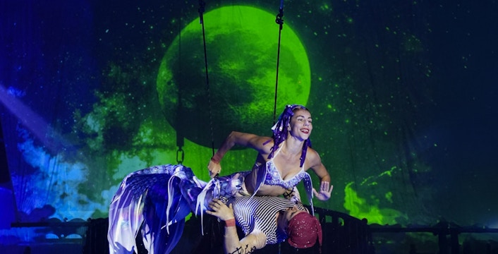 Aqua Circus Phuket performers in vibrant costumes executing an acrobatic water show.