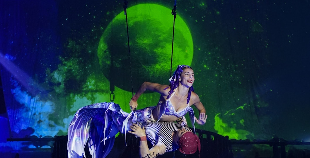 Aqua Circus Phuket performers in vibrant costumes executing an acrobatic water show.