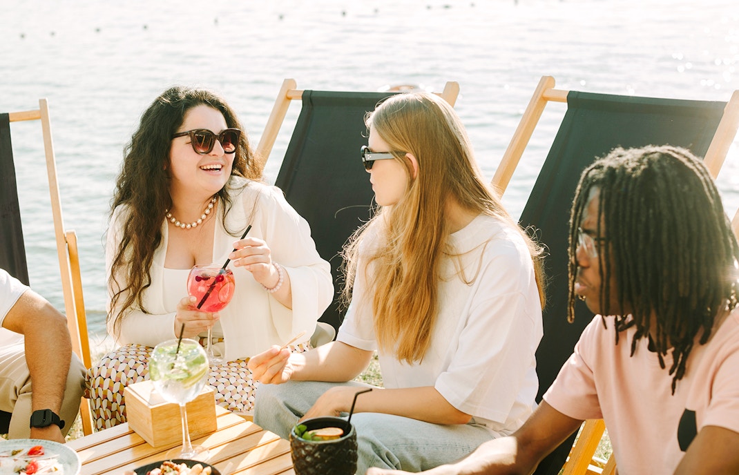 Group enjoying drinks by the sea at Cap d'Ail beach.