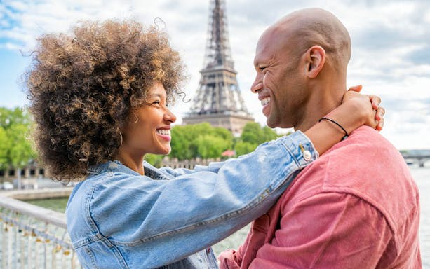 Couple embracing with Eiffel Tower in background during private photoshoot in Paris.