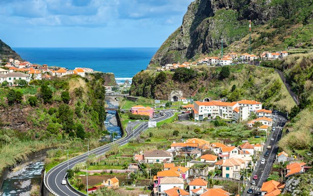 Cabo Girão cliffs and coastal village view on guided tour to Porto Moniz Lava Pools, Madeira.