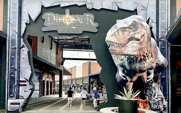 Entrance to Dinosaur Encounter World in Perak with large dinosaur sculpture.