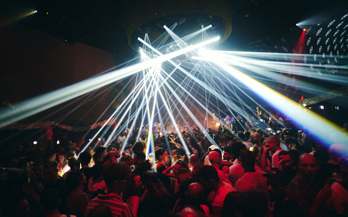 Crowd enjoying vibrant lights at TRIP Club Chinois.