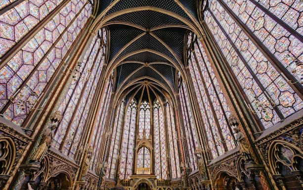 Sainte-Chapelle interior with ornate stained glass windows and vaulted ceiling in Paris.