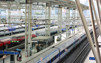 Korail trains at a busy station platform in South Korea.