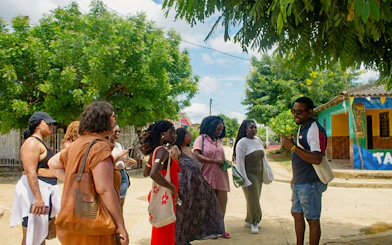 Visitors exploring San Basilio de Palenque streets with a local guide.