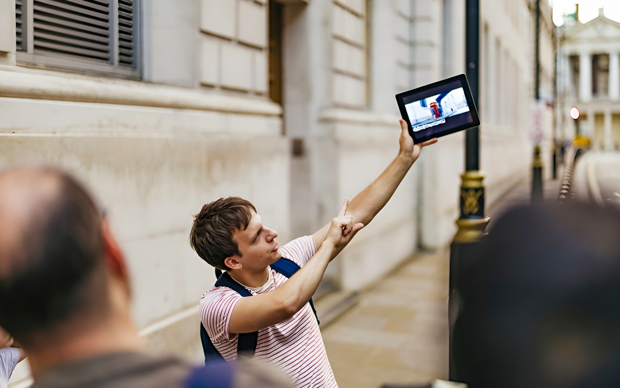 Guide showing Harry Potter film location on tablet during walking tour.