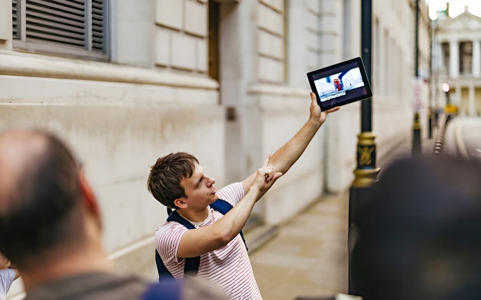 Guide showing Harry Potter film location on tablet during walking tour.