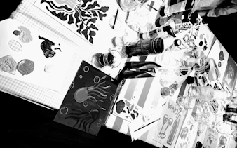 Painting supplies and drinks on a table during a Barcelona sip and paint night.
