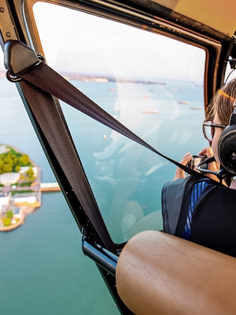 Helicopter view of Liberty Island, New York, with passenger taking photos.
