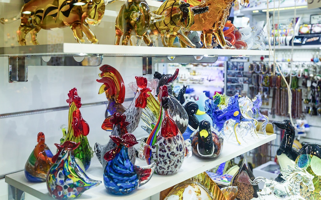 Murano glass animal figurines on display shelf in Venice, Italy.