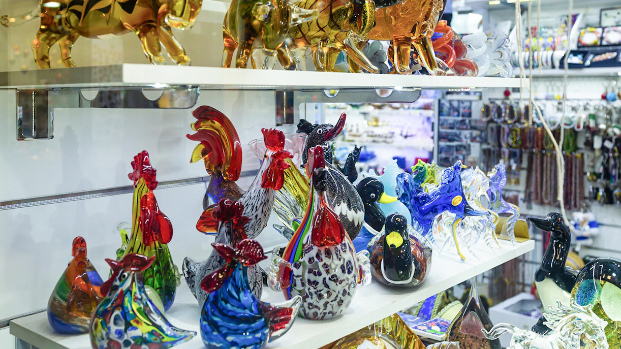 Murano glass animal figurines on display shelf in Venice, Italy.